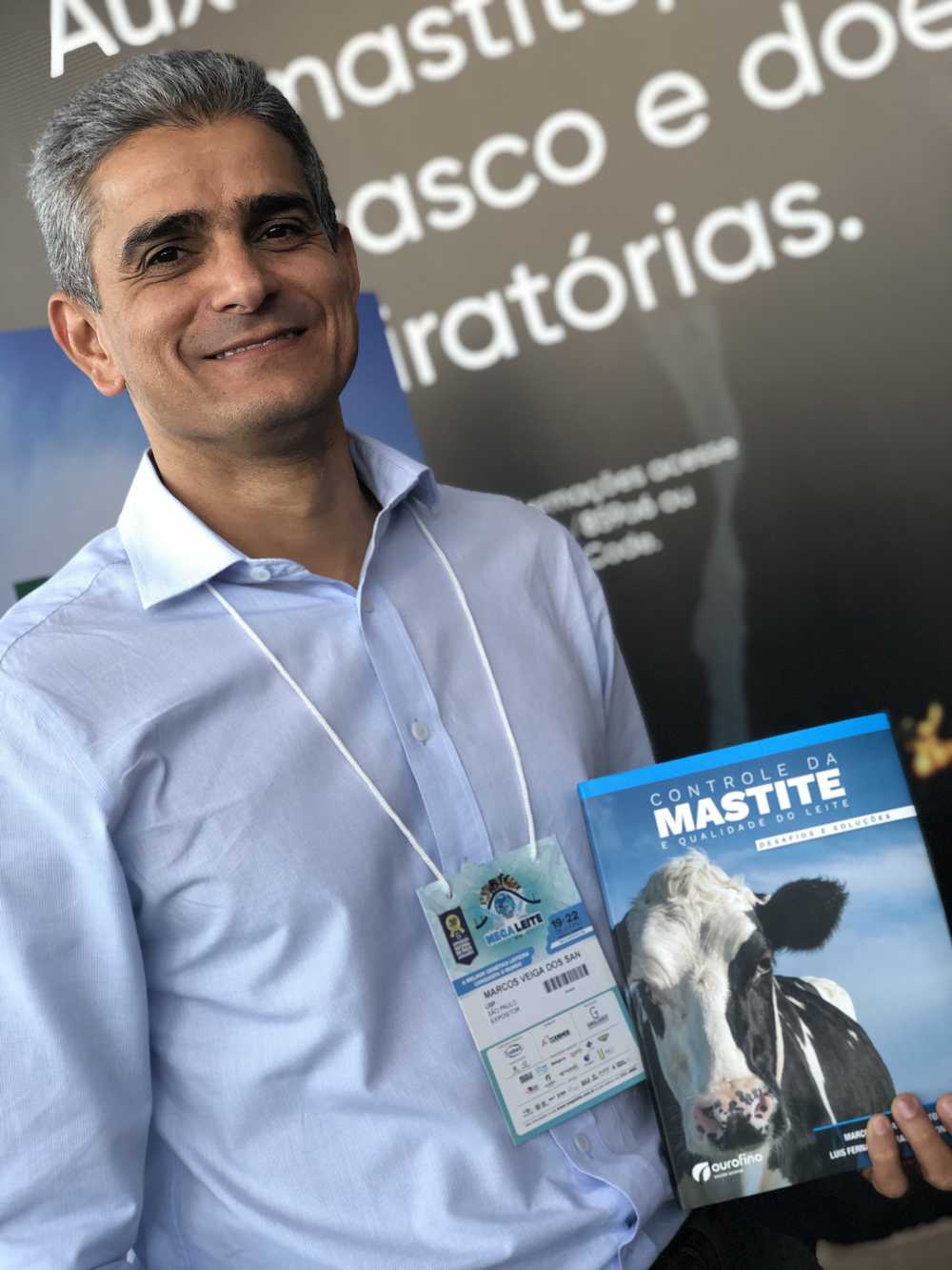 Professor Marcos Veiga segura o livro sobre mastite durante lançamenta na Megaleite 2019 